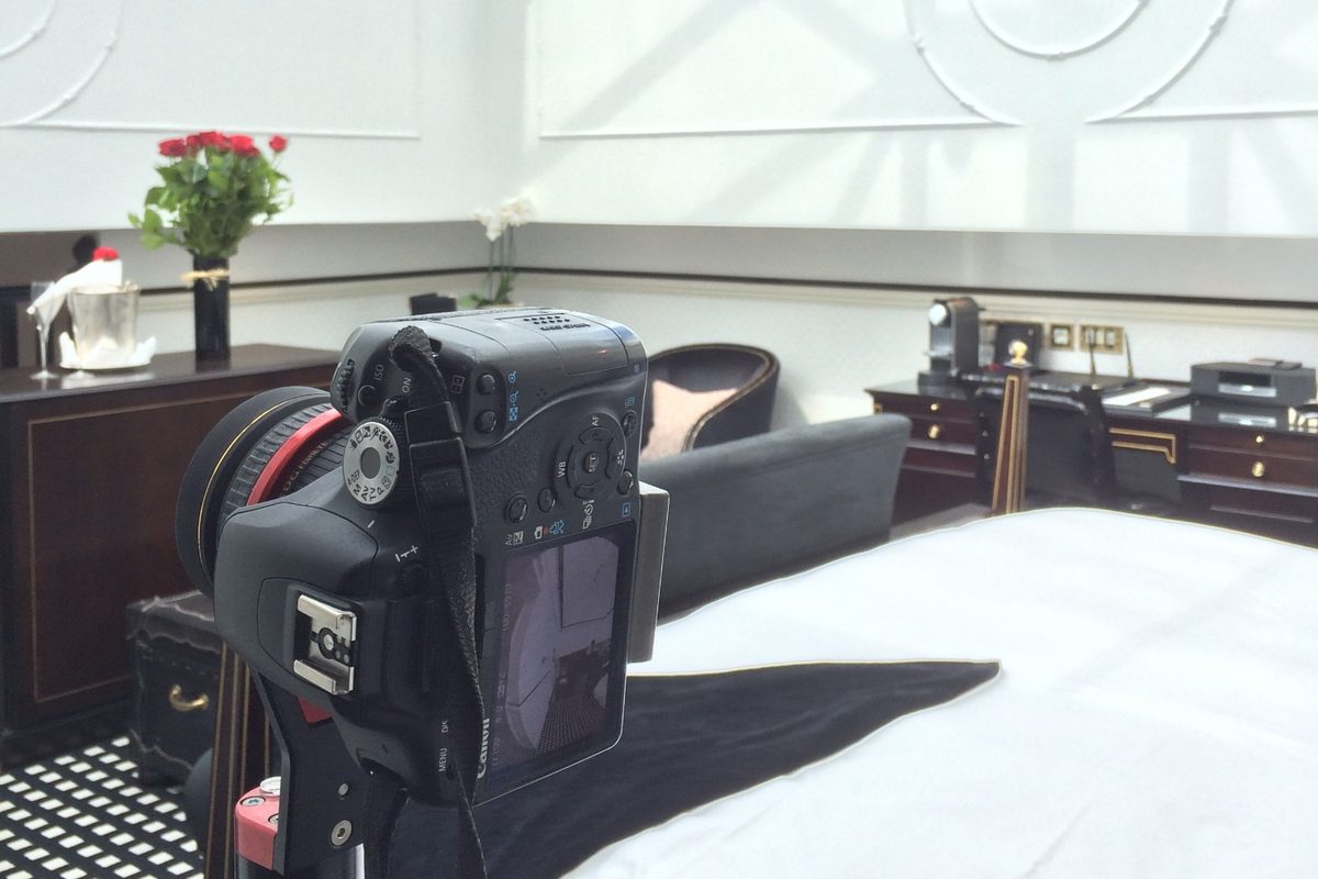A DSLR with a fisheye lens set up in a hotel suite